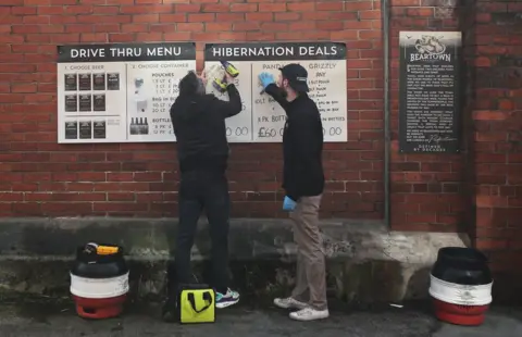 Reuters Workers put up beer menus at the Beartown Brewery drive thru in Congleton as the spread of the coronavirus disease (COVID-19) continues. Congleton