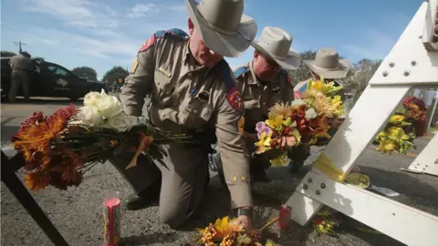 Getty Images Police lay flowers after texas shooting