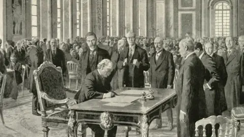 Getty Images The prime minister of Britain signing the Versailles Treaty in June 1919