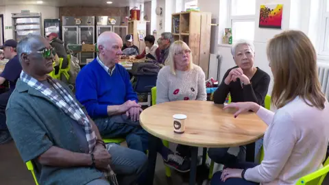 BBC Two male and two female pensioners sat at table in community centre in Salford
