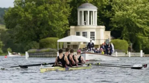 PA Media Four-man rowing crew, seen from behind, on the River Thames at the Henley Regatta