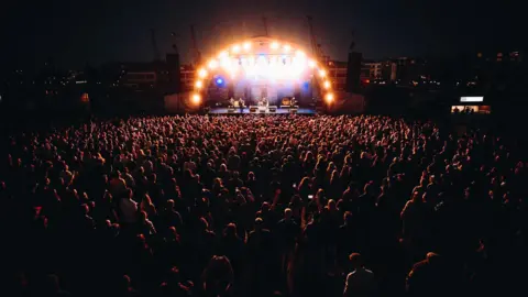 Nadine Ballantyne A crowd at Bristol Sounds 2024 illuminated by the stage lights