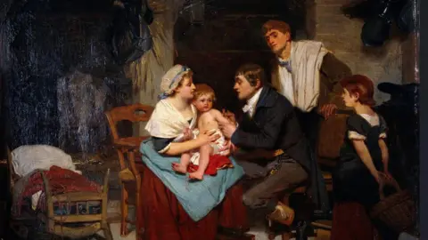 Getty Images A painting likely to be from the 19th century depicts a physician vaccinating a small child being held by his mother. Another man and a child are watching and a cot can be seen in the background. 