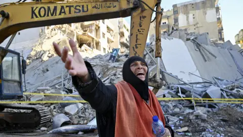 EPA A female reacts aft an Israeli aerial onslaught destroyed a multi-storey building successful nan confederate Beirut suburb of Chiyah (21 October 2024)