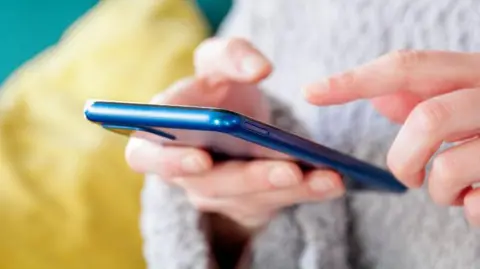 A stock image of someone texting on a mobile phone.
