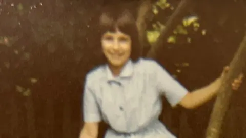 Isobel Lepist Isobel Lepist as a young girl smiles as she sits in the branches of a tree. She has dark shoulder-length hair with a fringe.