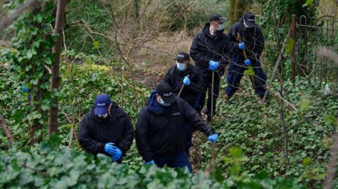 Police officers carry out searches at Kersal Dale