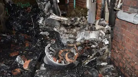 Lancashire Police Gnarled black twisted wreckage of an unrecognisable car.