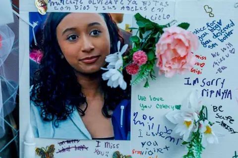 Los Angeles Times via Getty Images A photograph of Celeste Rivas Hernandez - who is smiling and has long, black hair - is stuck on a board alongside intimate notes and flowers.