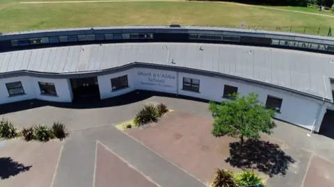 Aerial view of Mont à l’Abbé School’s secondary building, showing the curved modern building and surrounding grounds.