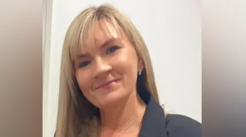 Thames Valley Police/Contributed Carol Georgiou standing in front of a white wall, wearing a black suit jacket and a silver necklace. She has long blonde hair and is smiling. 