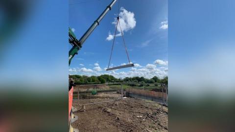 A crane lowers a beams into place
