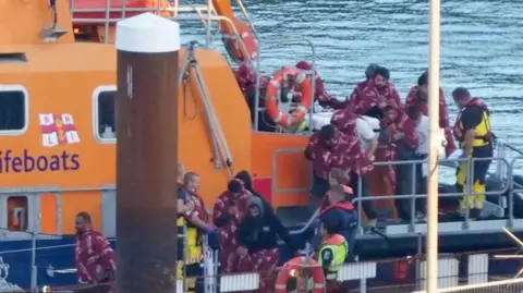 Migrants being put on a boat