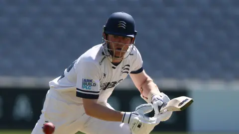 Sam Robson watches carefully as he steers a ball into the offside while batting at a sunny Lord's 