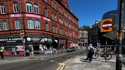Police tape outside of a shop and across a road in Birmingham city centre. 
