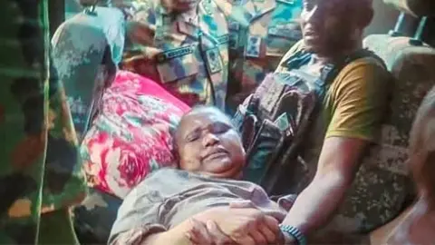 Nigerian Military officers surround Mrs Rabe Abubakar who was rescued after weeks in captivity
