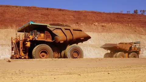 Zoe Corbyn Two large mining trucks pass each other in a mine in Western Australia