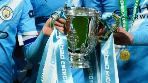 Manchester City players celebrate with the League Cup at Wembley in March