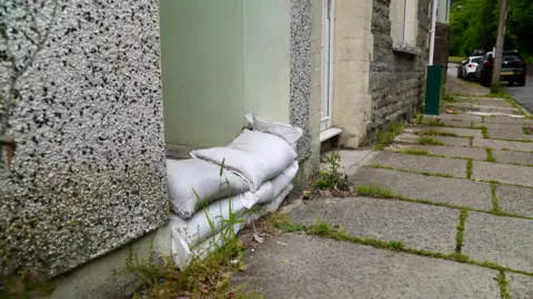 A picture showing sandbags in the doorway of one resident on Clydach Terrace.