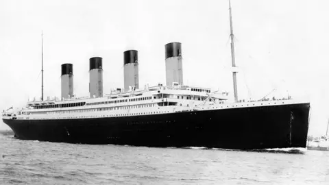 PA Media A black and white image of the four-funnelled RMS Titanic at sea