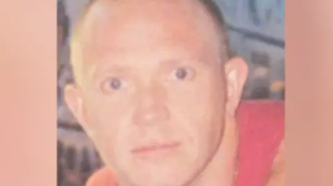 Neil Nortrop looking into the camera, he has blue eyes and short hair.