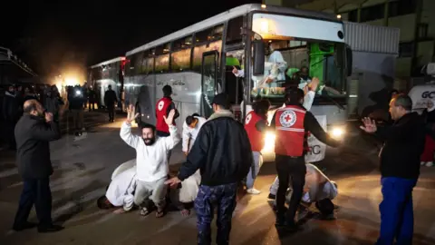 EPA Released Palestinian prisoners and detainees pray after reaching the European Gaza hospital in Khan Younis, southern Gaza (27 February 2025)