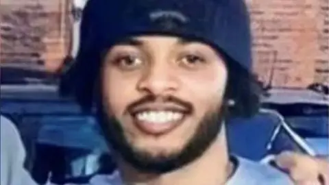 A picture of Salah Eldin Adam smiling wearing a blue hat