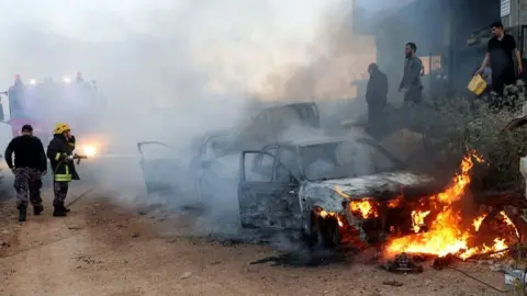 Anadolu/Getty Images Car ablaze after violence in al-Mughayyir, 12 Apr 24