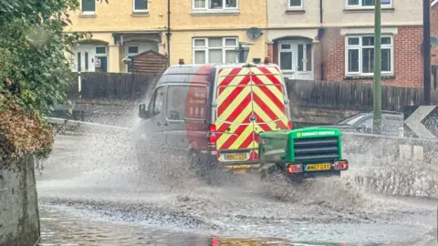 BBC Weather Watchers/StormChaserLiam   A van driving done  a ample  puddle