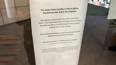 A piece of paper which announces the closure of The Cube Hotel and Marco Pierre White Steakhouse Bar & Grill and gives an email address if you have any queries.