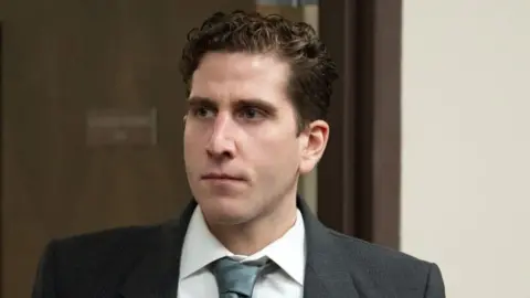 Bryan Kohberger wears a suit with a blank expression