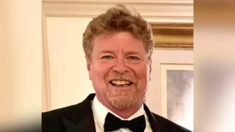 Robert Mabey Robert Mabey, who has curly light brown hair and a goatee, smiles at the camera. He is wearing a black suit jacket, white shirt and black bow tie.