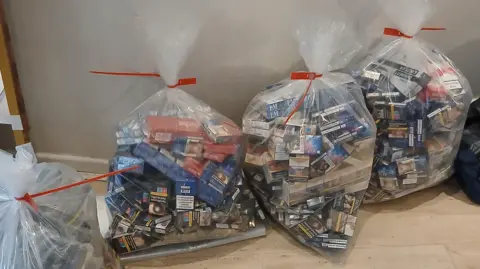 West Northamptonshire Council Four clear plastic bags packed full of boxes of cigarettes. Each is sealed with a red cable tie.