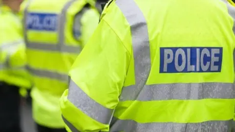 Stock image of police officers with their backs to the camera.