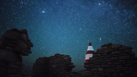 Bruce Frank Stars over rocky walls and a lighthouse