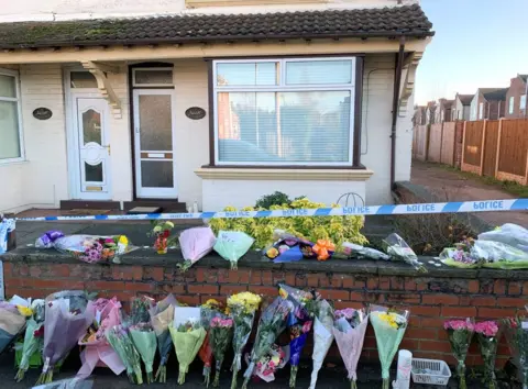 PA Media Flowers outside house in Station Road