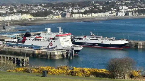 A view from Douglas Head, you can see the Ben-my-Chree a tall boxy ferry, and Manannan a sleek catamaran moored up in the harbour, with buildings along Douglas prom in the background.