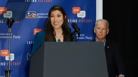 Getty Images Lucy Flores speaking at a 2014 Nevada campaign event with Joe Biden behind her