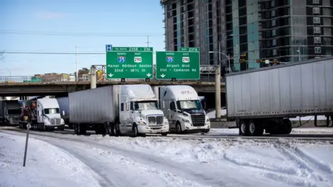 Getty Images Trucks wait in traffic in Austin, Texas delayed by winter storm Uri