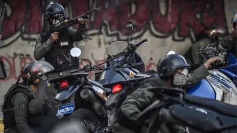 AFP Venezuelan security forces take cover upon coming under fire during a confuse skirmish in Caracas on July 30, 2017