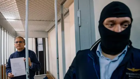 AFP Mr Whelan was guarded in the defendants' cage by a balaclava-clad FSB officer