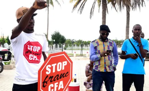 AFP A man holds up his fist during an anti-colonial demonstration against the regional CFA franc in Dakar, Senegal -16 September 2017