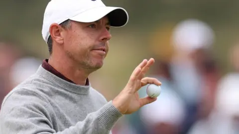 Rory McIlroy holds up a ball in acknowledgement to fans at Royal Portrush