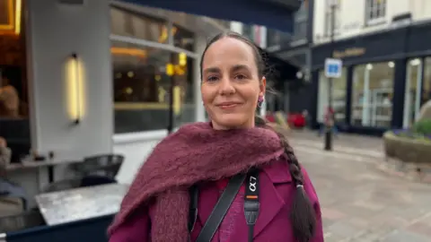 A woman standing in the town centre.