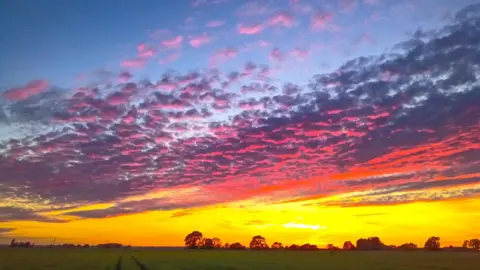 alpaca lady/BBC Weather Watchers The sky over Ramsey St Marys scattered with clouds painted blue, pink and orange.
