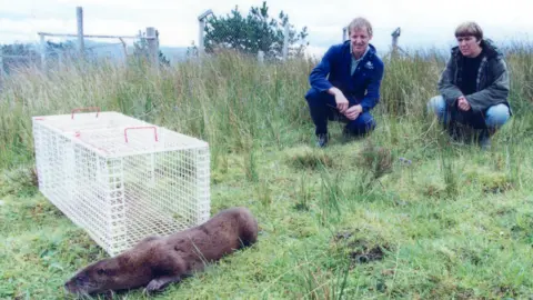 IOSF Dr Paul Yoxon with Grace Yoxon from IOSF released an otter back into the wild