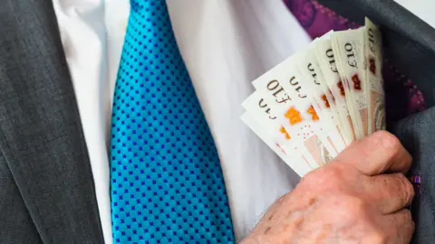 Getty Images Man with £10 notes