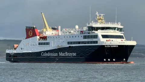 A black and white ship with red funnels with Caledonian MacBrayne written on the sides