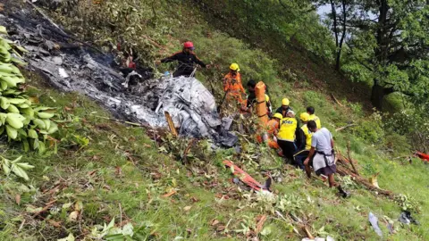 Members of rescue teams work at the site of a chopper crash in the Gaurikund area of the northern Indian state of Uttarakhand, India