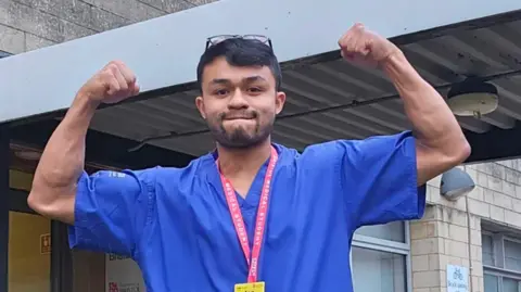 University of Bristol A man with scrubs on flexing his muscles